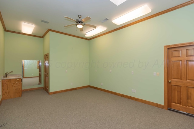 carpeted spare room featuring ceiling fan and ornamental molding