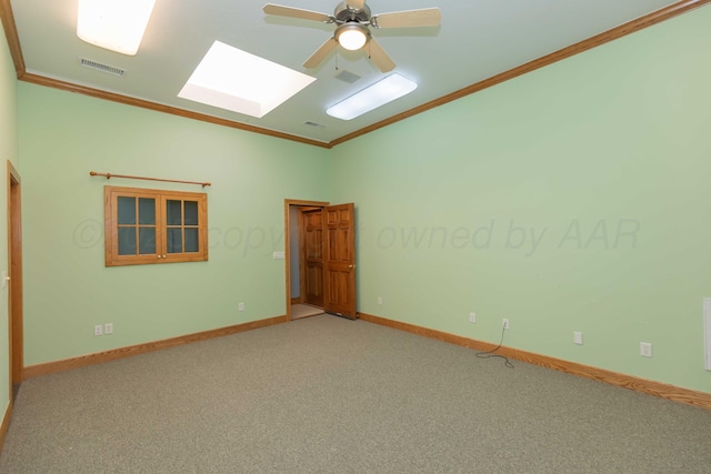 empty room featuring crown molding, a skylight, ceiling fan, and carpet