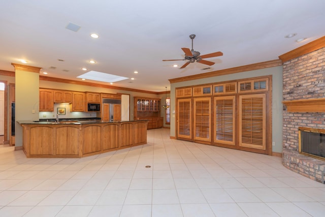 kitchen with a skylight, crown molding, a fireplace, and kitchen peninsula