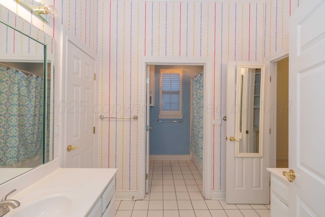 bathroom with tile patterned flooring, vanity, and walk in shower