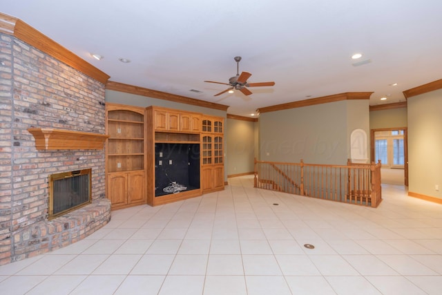 unfurnished living room featuring crown molding, ceiling fan, a brick fireplace, and light tile patterned floors