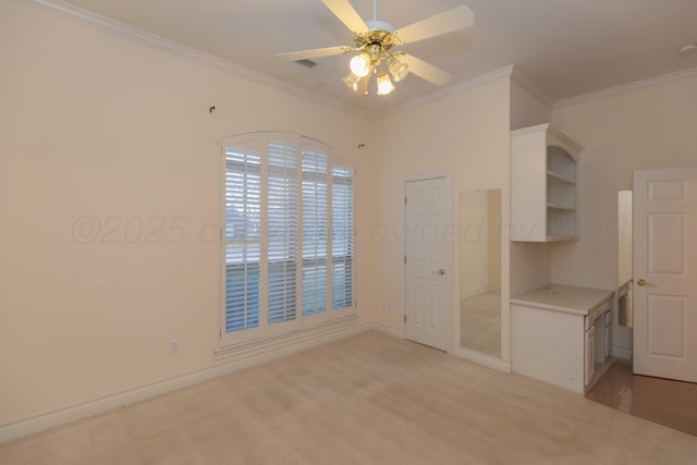 unfurnished bedroom featuring crown molding, light colored carpet, and ceiling fan