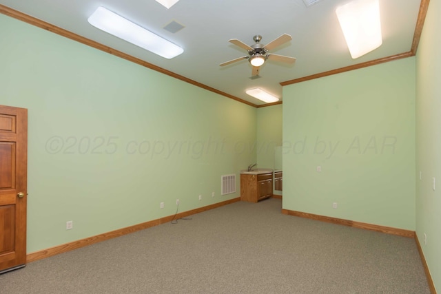 carpeted empty room with ornamental molding, vaulted ceiling, and ceiling fan