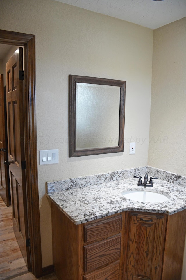 bathroom with vanity and wood-type flooring