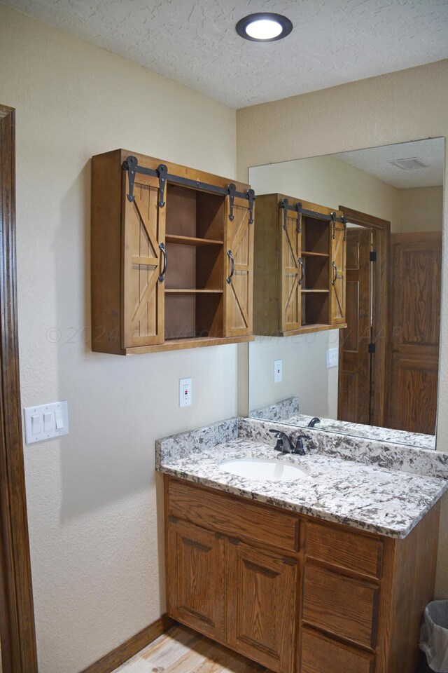 kitchen featuring light hardwood / wood-style floors, sink, and light stone counters