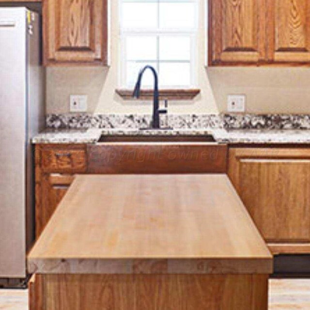 kitchen featuring sink, stainless steel fridge, and a center island