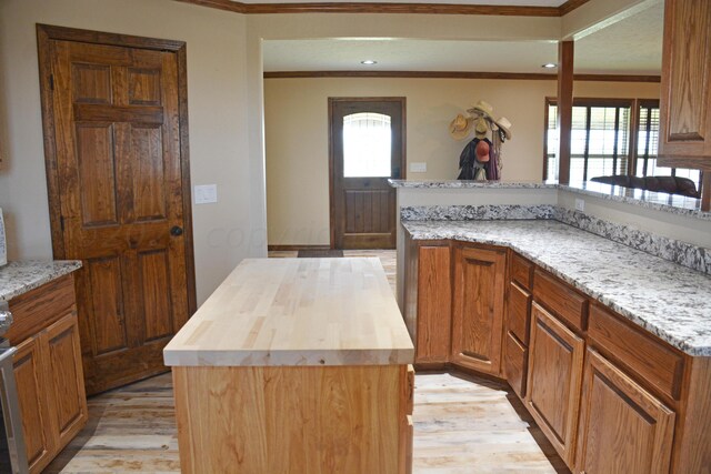 kitchen featuring light wood-type flooring, plenty of natural light, butcher block counters, and a kitchen island