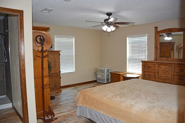 bedroom featuring ceiling fan, a textured ceiling, and light wood-type flooring