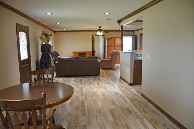 living room with light wood-type flooring, ceiling fan, and ornamental molding