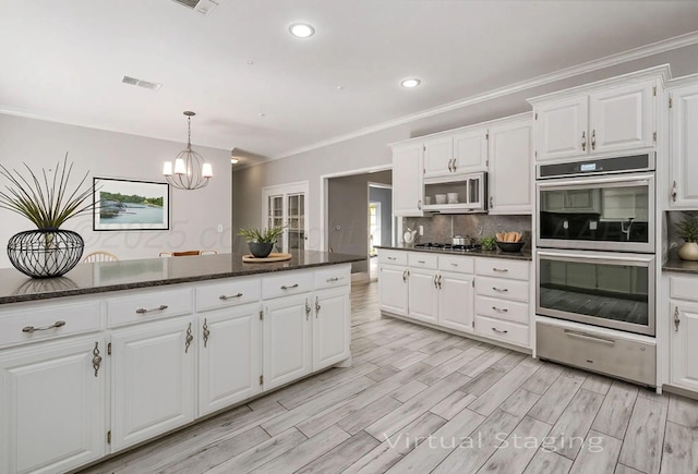 7715 Tarrytown Ave, Amarillo, TX 79121 - kitchen with appliances with stainless steel finishes, white cabinets, a chandelier, a warming drawer, and recessed lighting