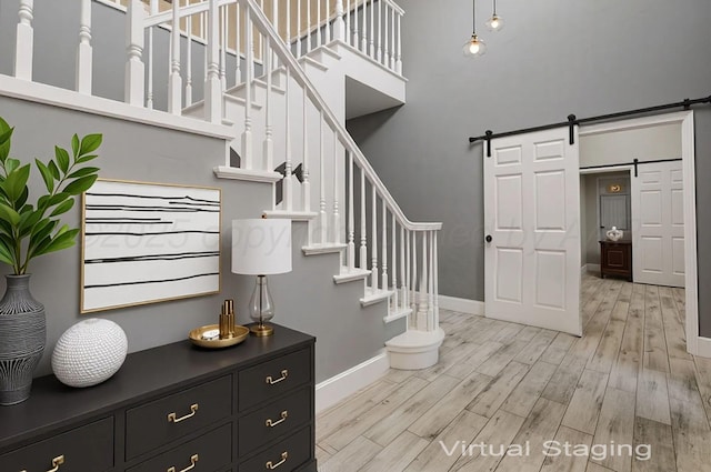 7715 Tarrytown Ave, Amarillo, TX 79121 - staircase featuring a barn door, wood finished floors, and a high ceiling