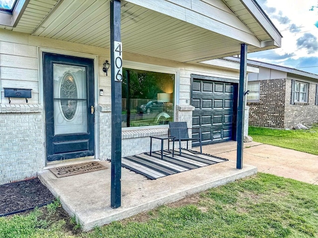 entrance to property featuring covered porch and a garage