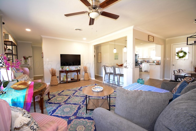 living room with ceiling fan, ornamental molding, and wood-type flooring