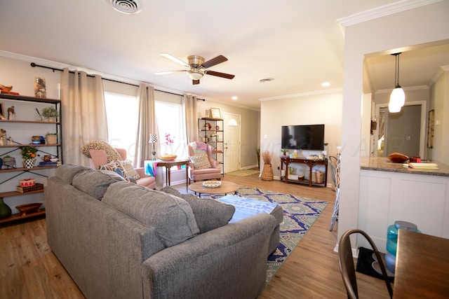 living room featuring ceiling fan, ornamental molding, and hardwood / wood-style floors