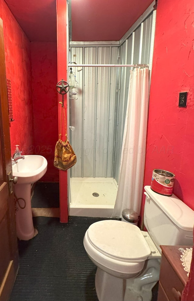 bathroom featuring toilet and a shower with curtain