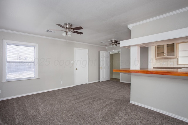 1928 Cherry St, Amarillo, TX 79106 - unfurnished living room with a ceiling fan, ornamental molding, dark carpet, and built in study area
