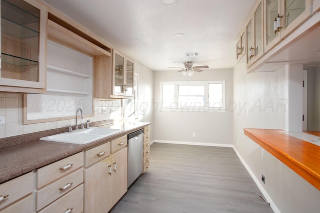 1928 Cherry St, Amarillo, TX 79106 - kitchen with stainless steel dishwasher, tasteful backsplash, a ceiling fan, light wood-style floors, and glass insert cabinets