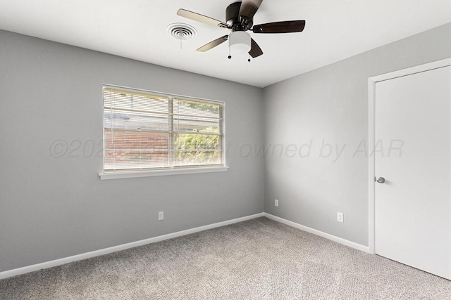 empty room with visible vents, carpet flooring, ceiling fan, and baseboards