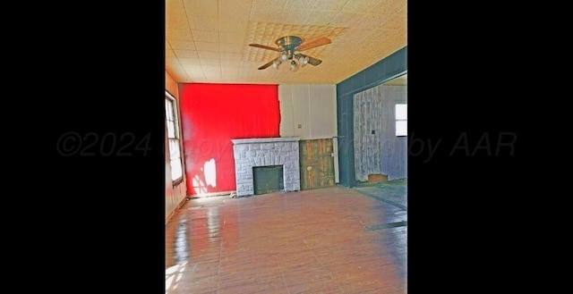 living room with ceiling fan and a fireplace