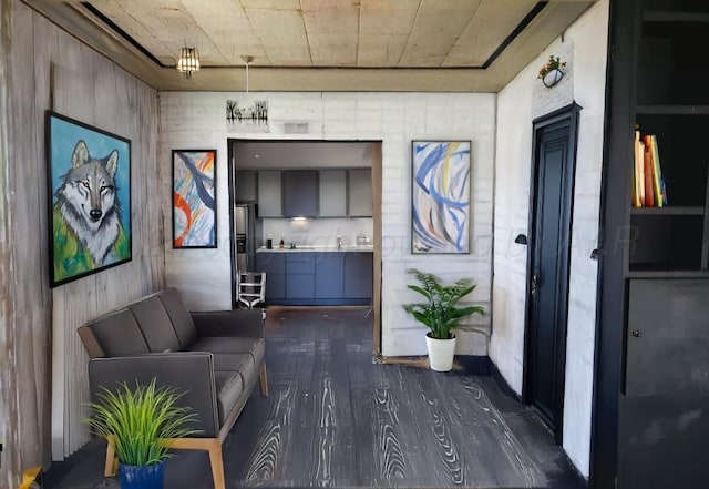 living area featuring dark hardwood / wood-style floors and wood walls