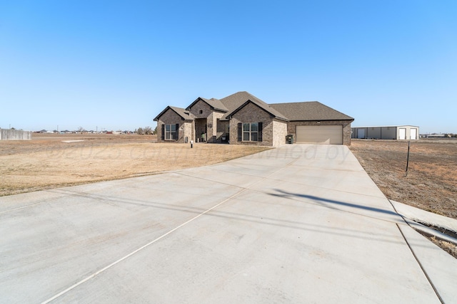 view of front of property featuring an attached garage, brick siding, and driveway