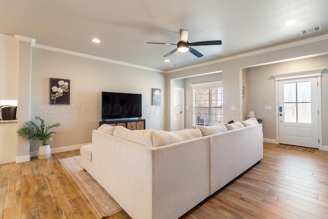 living area featuring light wood-style floors, ceiling fan, and crown molding