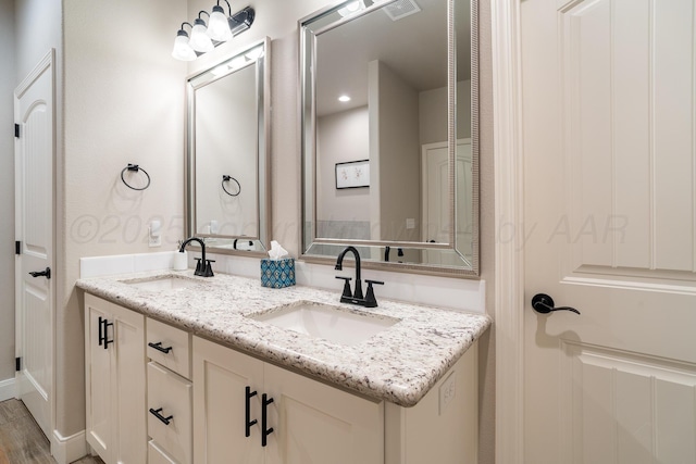 bathroom featuring double vanity, visible vents, and a sink