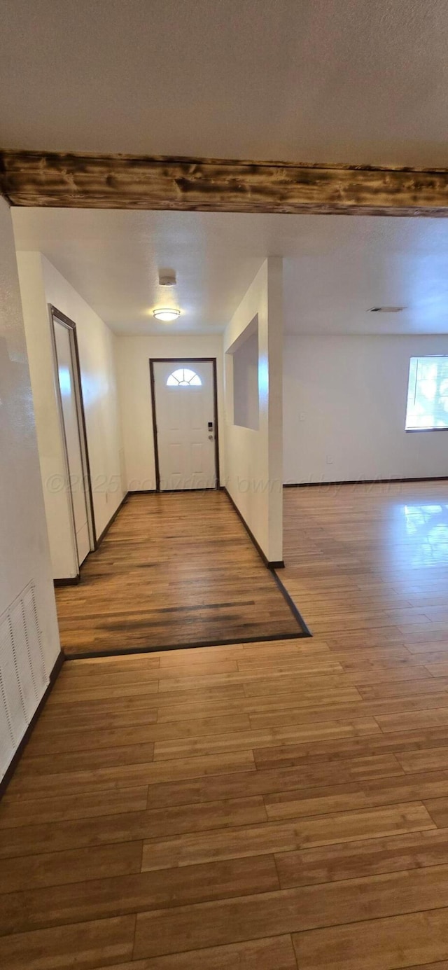 foyer entrance with hardwood / wood-style flooring and beamed ceiling