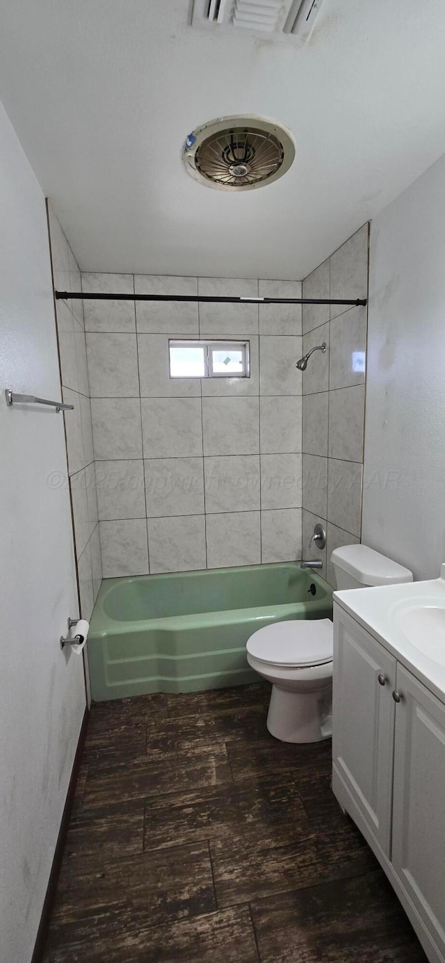 full bathroom with vanity, hardwood / wood-style flooring, toilet, and tiled shower / bath