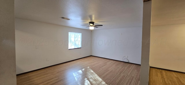 empty room featuring ceiling fan, light hardwood / wood-style floors, and a textured ceiling