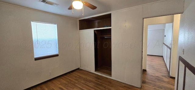 unfurnished bedroom with hardwood / wood-style floors, a closet, ceiling fan, and ornamental molding