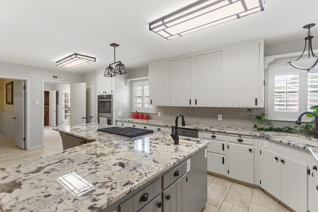 kitchen with white cabinetry, backsplash, a sink, visible vents, and appliances with stainless steel finishes