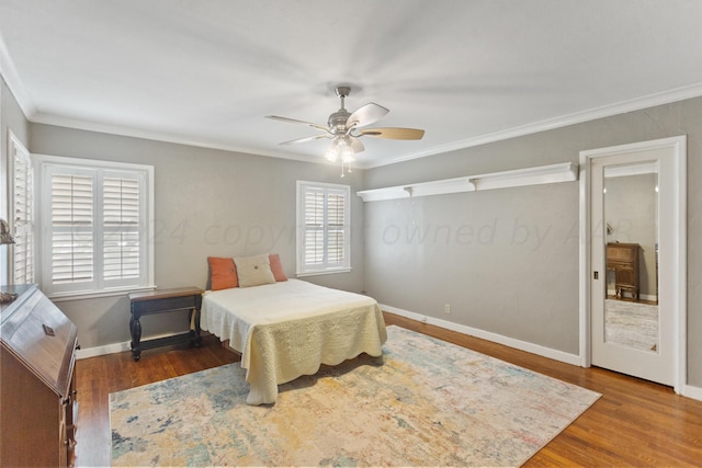 bedroom with baseboards, wood finished floors, ornamental molding, and a ceiling fan