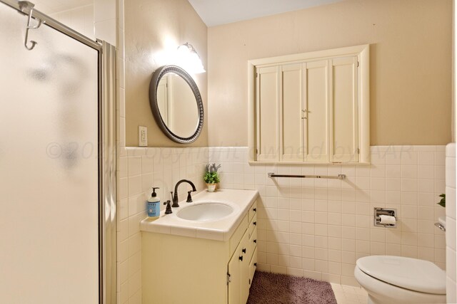 full bath featuring tile walls, a wainscoted wall, toilet, and a stall shower