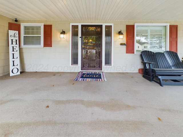 property entrance featuring a porch and concrete block siding