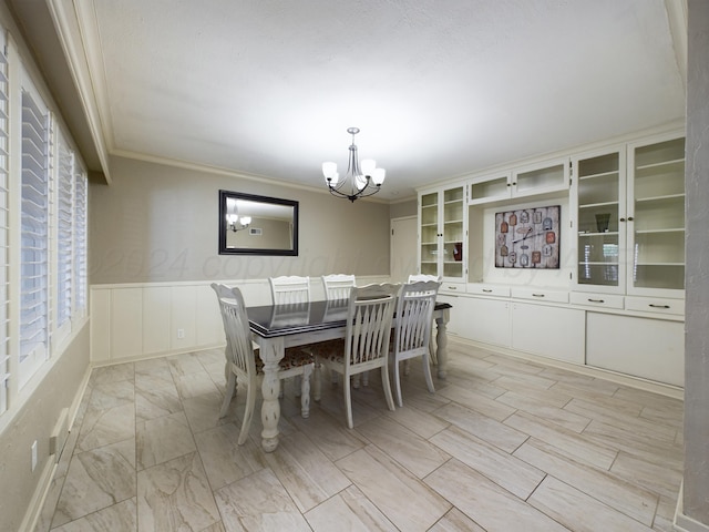 unfurnished dining area with a decorative wall, crown molding, a notable chandelier, and wainscoting