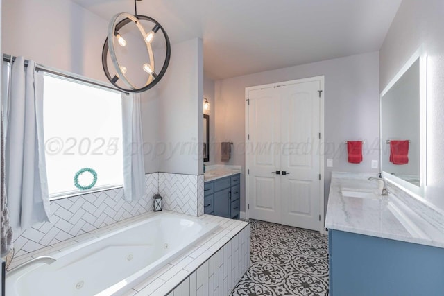 bathroom featuring tiled bath, vanity, and tile patterned flooring