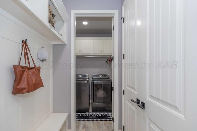 mudroom with light wood-type flooring and washing machine and dryer