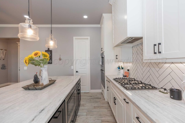 kitchen with pendant lighting, decorative backsplash, ornamental molding, white cabinets, and light stone counters