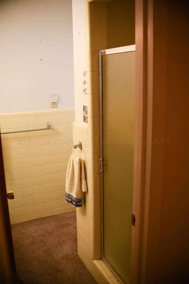 bathroom with an enclosed shower and tile walls