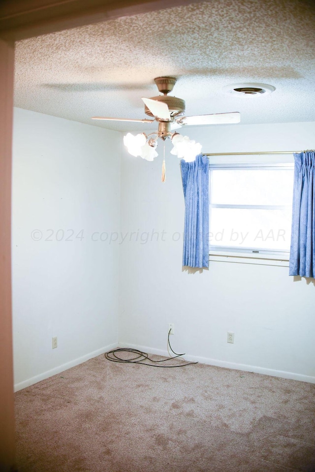 carpeted spare room featuring a textured ceiling and ceiling fan