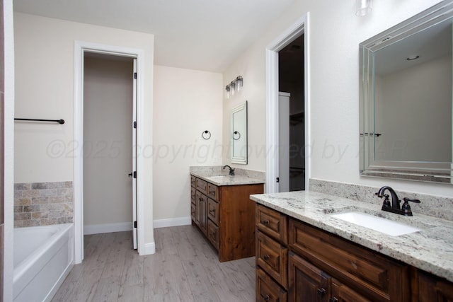 9407 Kori Dr, Amarillo, TX 79119 - bathroom with baseboards, wood finished floors, two vanities, and a sink