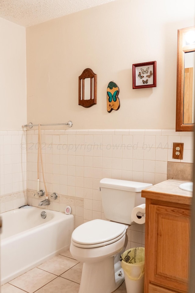 bathroom featuring vanity, tile patterned floors, a textured ceiling, and tile walls