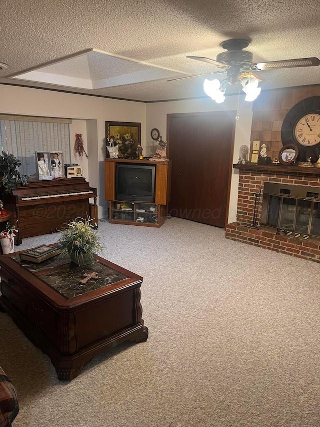 living room featuring carpet flooring, a brick fireplace, a textured ceiling, and ceiling fan