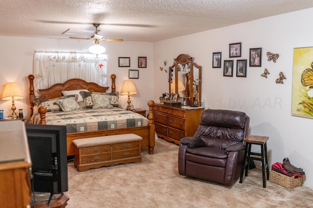 bedroom featuring a textured ceiling, light colored carpet, and ceiling fan