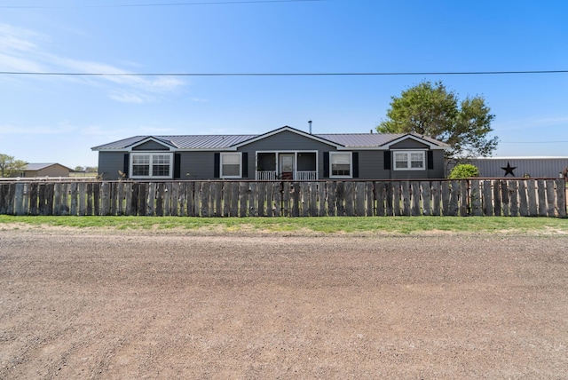 view of front of property with fence and metal roof