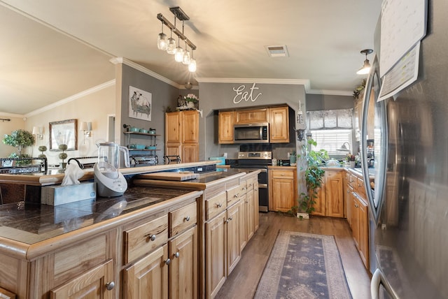 kitchen with stainless steel appliances, pendant lighting, ornamental molding, dark wood-type flooring, and visible vents