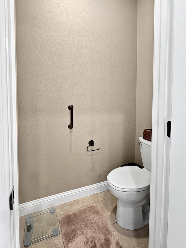 bathroom featuring toilet, baseboards, and tile patterned floors
