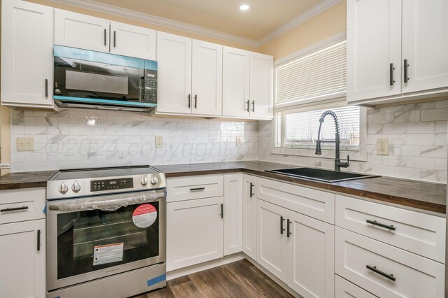 kitchen with tasteful backsplash, stainless steel electric range oven, sink, and white cabinets