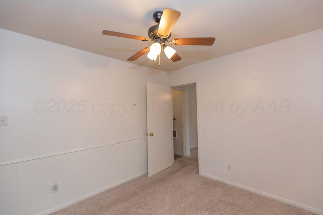 empty room with a ceiling fan, baseboards, and light colored carpet